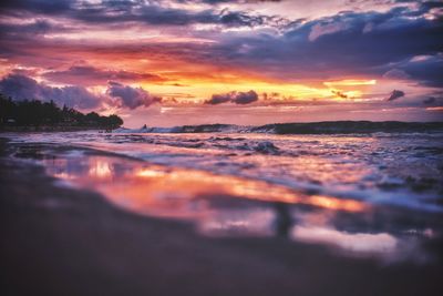 Scenic view of sea against dramatic sky during sunset