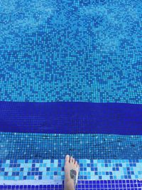 Low section of woman standing at poolside