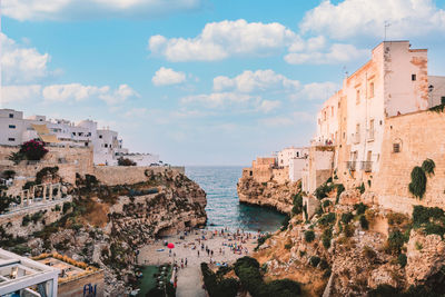 Famous beach of polignano a mare in summer day with sky with white clouds