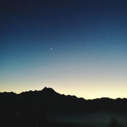 Scenic view of silhouette mountains against sky at night