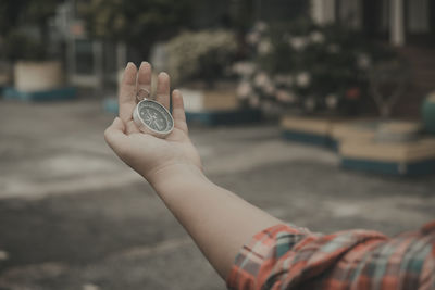 Close-up of hand holding coin