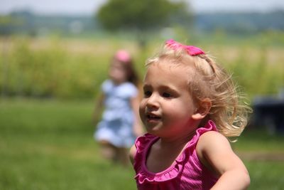 Close-up of thoughtful girl running on field