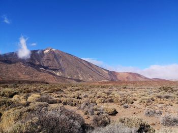 Scenic view of volcanic mountains against clear blue sky