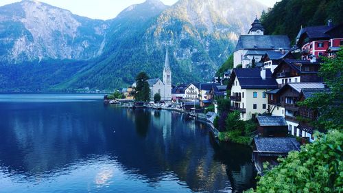 Houses by lake and buildings in city