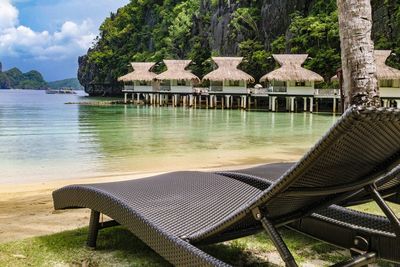 Lounge chairs on beach against sky