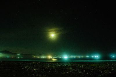 Illuminated city against sky at night