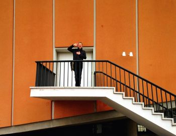 Low angle view of woman standing by railing