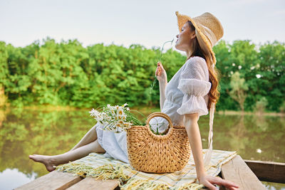 Side view of woman sitting on field