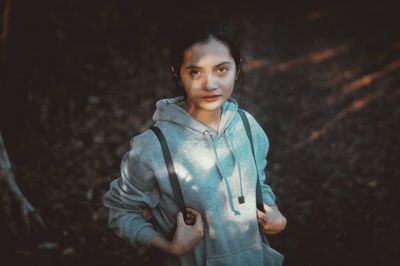 Portrait of young woman standing in forest