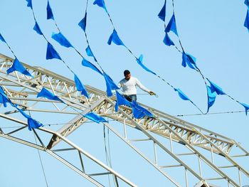 Low angle view of man against blue sky