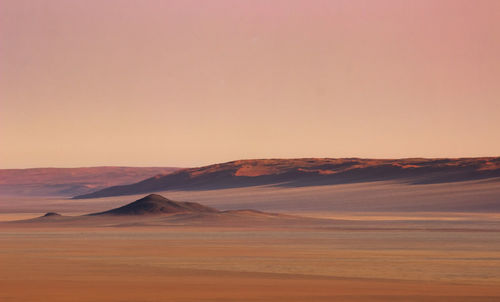 Scenic view of desert against sky during sunset