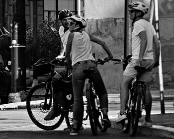 Men riding bicycle on street in city