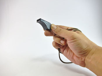 Close-up of person holding camera against white background