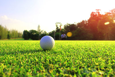 Close-up of golf ball on field against sky