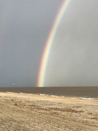 Scenic view of rainbow over sea against sky