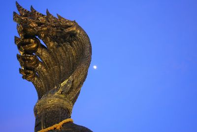 Low angle view of sculpture against clear sky at night