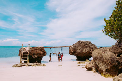 People standing on beach against sky