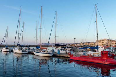Sailboats moored in harbor