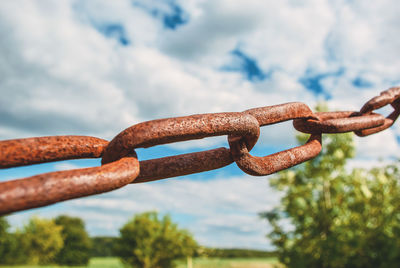 Old rusty chain on the field on background of the sky