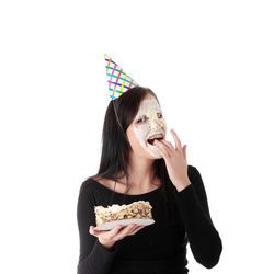 Portrait of woman eating food against white background