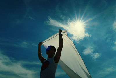 Low angle view of person against blue sky