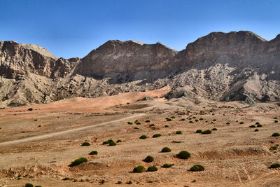 Scenic view of landscape and mountains against clear sky