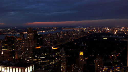 Illuminated buildings in city against sky at night