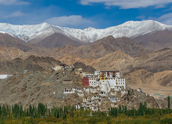 Scenic view of mountains and houses against sky