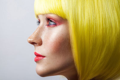 Close-up of woman looking away against white background