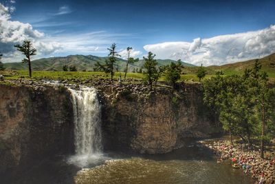 Scenic view of waterfall against sky