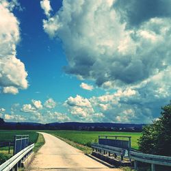 Empty road against cloudy sky