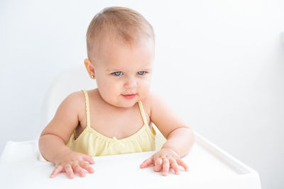 Portrait of cute girl writing in book against white background