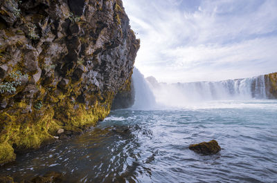 Scenic view of waterfall against sky