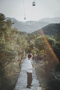 Side view of man standing on mountain road