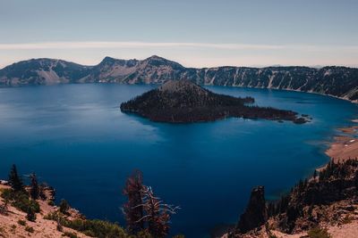Scenic view of sea and mountains against sky