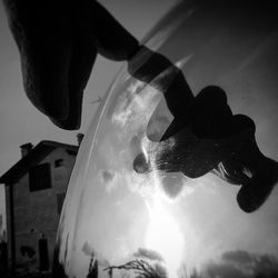 Close-up of hand against sky in city