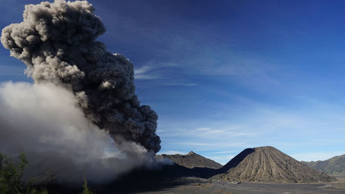 Smoke emitting from volcanic mountain against sky