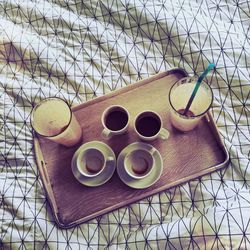 High angle view of empty coffee cups on tray at bed