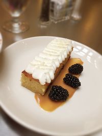 High angle view of hazelnut cake with blackberries served in plate on table