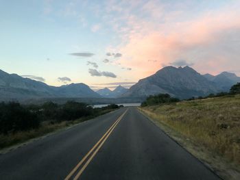 Empty road against mountains and sky