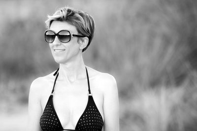 Smiling mature woman wearing bikini at beach