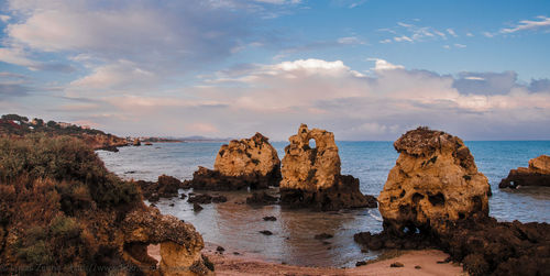 Rock formations by sea against sky