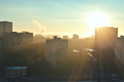 Buildings in city against sky during sunset