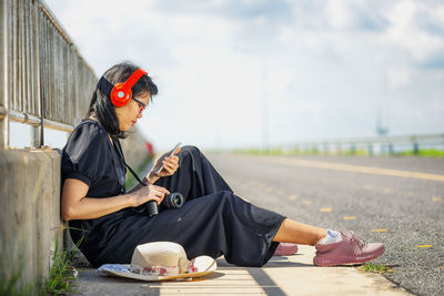 Midsection of woman sitting with umbrella