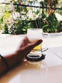 Midsection of person holding drink on table