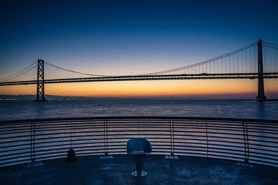 Bay bridge against clear sky at sunrise