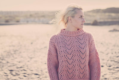 Young woman wearing sweater while looking away
