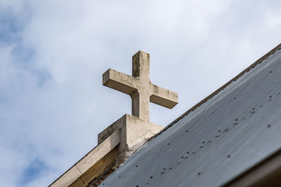 Low angle view of cross against sky