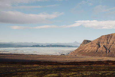 Scenic view of sea and mountains against sky