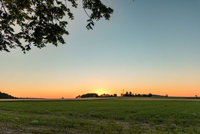 Scenic view of field against clear sky during sunset